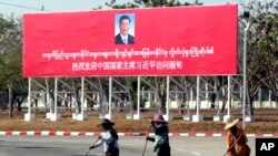 រូបឯកសារ៖ អ្នកបោសសម្អាតនៅខាងមុខផ្ទាំងស្វាគមន៍​ប្រធានាធិបតីចិនលោក Xi Jinping កាលពីថ្ងៃទី១៧ ខែមករា ឆ្នាំ២០២០។ 