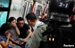 Commuters react as police officers looking for protestors raid a metro train, in Hong Kong, China September 1, 2019.