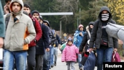 Para migran setelah melewati perbatasan Austria-Jerman dekat Wegscheid, Jerman (12/11). (Reuters/Michaela Rehle)