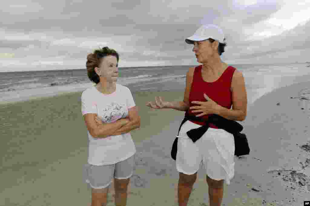 Charlotte Timmons, 63, and Brenda Batey, 60, discuss their concerns about community preparations for Tropical Storm Isaac during their morning walk along the beach in west Gulfport, Miss., Aug. 28, 2012. 