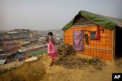 A Rohingya Muslim girl wears a sweater standing outside her tent at Balukhali refugee camp 50 kilometres (32 miles) from Cox's Bazar, Bangladesh, Jan. 14, 2018.