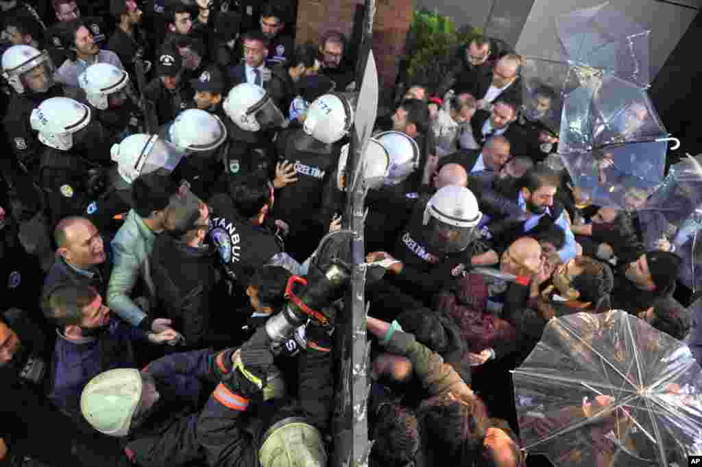Riot police enter the headquarters of opposition Bugun newspaper and Kanalturk television station in Istanbul, Turkey. Police carried out a dawn raid, using tear gas to enter the headquarters of a media company linked to a government critic, enforcing a court order to seize the business. 