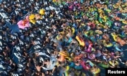 大眾在中國遼寧省撫順市的一個游泳館裡玩水避暑。（2017年7月31日）
