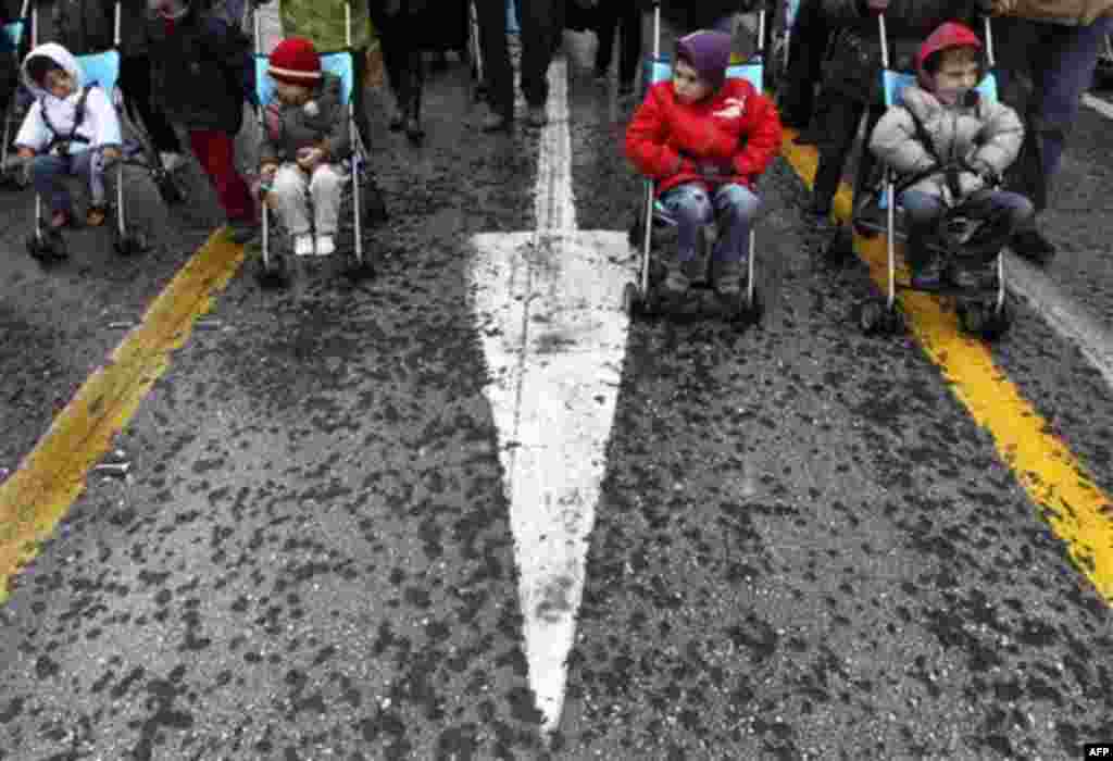 Children from the Greek Association of Large Families take part in a rally during a protest in central Athens, on Wednesday, Dec. 15, 2010. Hundreds of protesters clashed with riot police across central Athens Wednesday, smashing cars and hurling gasoline