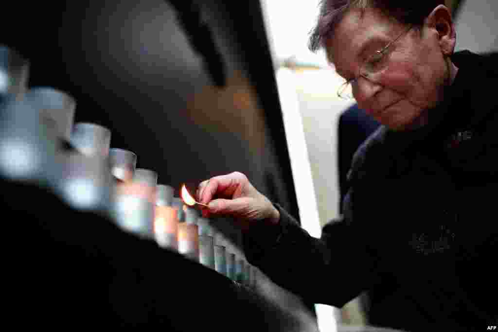 Holocaust survivor Josiane Traum lights a memorial candle during an International Holocaust Remembrance Day Commemoration at the United States Holocaust Memorial Museum, in Washington, D.C.