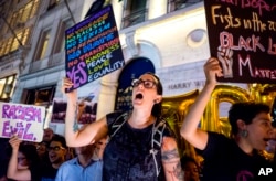 Protesters near Trump Tower react as President Donald Trump arrives, Aug. 14, 2017, in New York.