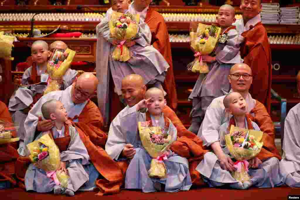 Novice monks who had their heads shaved by pose for photographs with Buddhist monks during an event to celebrate the upcoming Vesak Day, the birthday of Buddha, at Jogye temple in Seoul, South Korea.