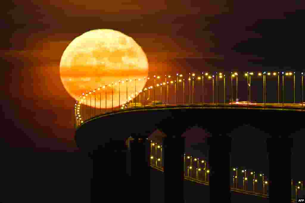 A full moon rising over the Re Island Bridge in Rivedoux, France.