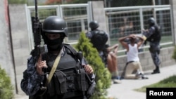 Salvadoran policemen participate in an anti-gang search operation in San Salvador, June 21, 2015. 