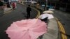 A man walks past an umbrella installation in the occupied area outside government headquarters in Hong Kong's Admiralty, Oct. 28, 2014.