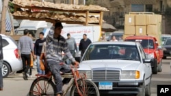 In this March 16, 2013 photo, an Egyptian bread vendor rides his bicycle in downtown Cairo.