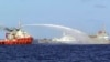 FILE - A Chinese ship (L) shoots a water cannon at a Vietnamese vessel (R) while a Chinese Coast Guard ship (C) sails alongside in the South China Sea, off Vietnam's coast, May 7, 2014. 