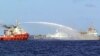 In this photo released by Vietnam Coast Guard, a Chinese ship (L) shoots a water cannon at a Vietnamese vessel (R) while a Chinese Coast Guard ship (C) sails alongside in the South China Sea, off Vietnam's coast, May 7, 2014. 