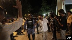 Supporters of Maldives' former President Mohamed Nasheed taunt a police officer during a protest in Male, Maldives, Sunday, Feb. 12, 2012.