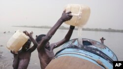 Des enfants soudanais remplissent un réservoir d'eau du Nil à Khartoum, au Soudan, 5 mai 2009.