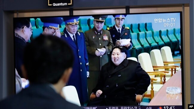 一名男子在韩国首尔火车站观看朝鲜试射“新型战术制导武器”的电视新闻，其中包括朝鲜领导人金正恩的镜头（2019年4月18日）。