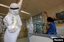 Pekerja medis di RS Persahabatan mengajak seorang pasien di Unit Perawatan Intensif (ICU) untuk pasien Covid-19, berolahraga, 13 Mei 2020. (Foto: Reuters)