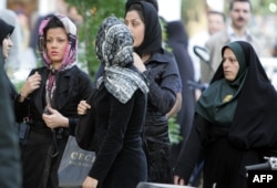 An Iranian policewoman (R) warns women about their clothing and hair during a crackdown to enforce Islamic dress code in Tehran, April 23, 2007. AFP/Atta Kenare