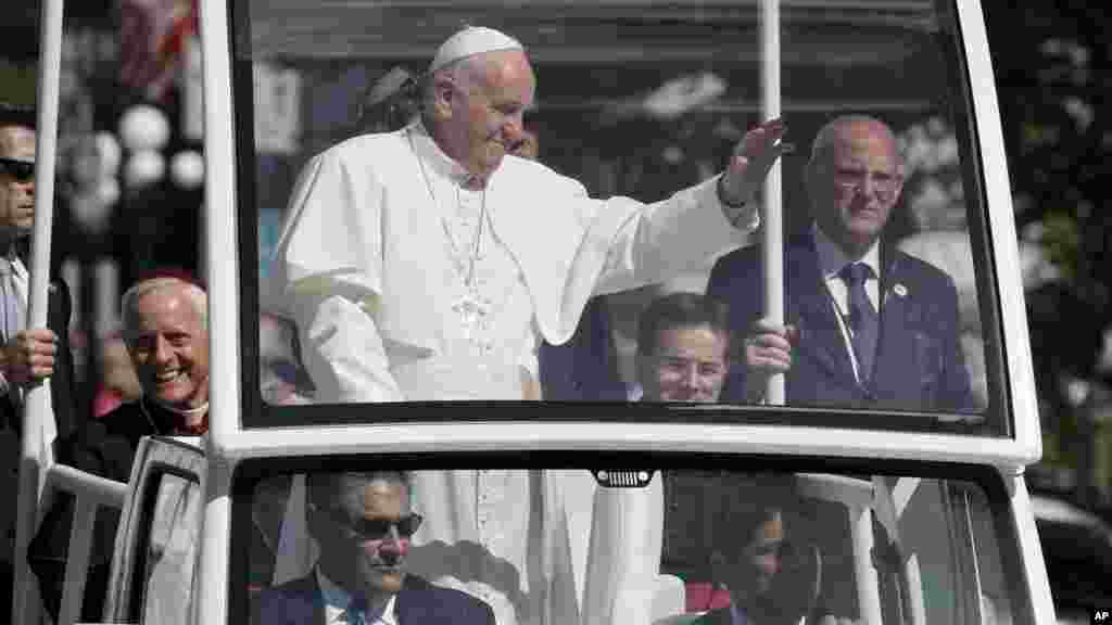 Le cardinal Donald Wuerl, archevêque de Washington, à gauche, sourit, à bord de la papa mobile d&#39;où&nbsp;le pape François salue la foule à Washington, 23 septembre 2015.