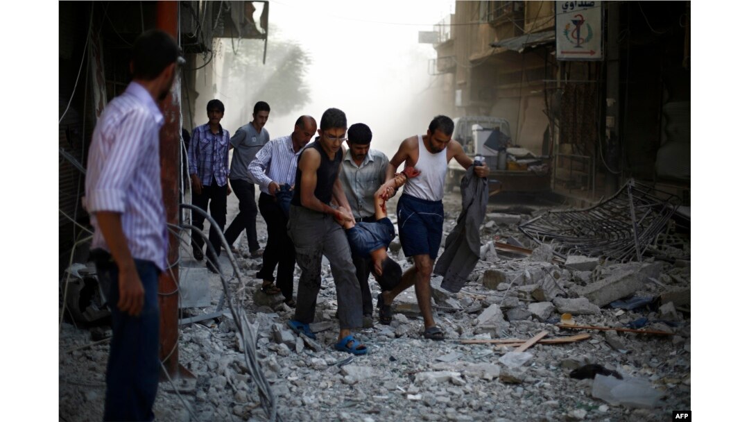 Syrians carry a wounded man following reported air strikes by Syrian government forces on the rebel-held town of Douma, east of the Syrian capital Damascus, on Oct. 2, 2015.