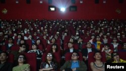 Espectadores ven un filme con espejuelos tridimensionales en una sala de cine en China.