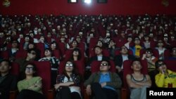 Espectadores ven un filme con espejuelos tridimensionales en una sala de cine en China.