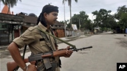 FILE - An Indian armed security man stands guard in Kokrajhar, India, July 24, 2012. Authorities say 15 people were wounded in the attack Friday in Kokrajhar, 220 kilometers west of the state commercial capital, Guwahati.