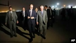 Secretary of State Rex Tillerson, right, walks on the tarmac as he arrives at Baghdad International Airport, Oct. 23, 2017, in Baghdad, Iraq.