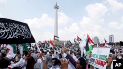 Para pengunjuk rasa di pelataran Monumen Nasional (Monas), Jakarta, Jumat, 11 Mei 2018, meneriakkan "Allahu Akbar" dalam aksi mereka menentang rencana pemerintah AS yang akan memindahkan kedutaan dari Tel Aviv ke Yerusalem. (Foto: AP/Achmad Ibrahim).