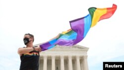 Joseph Fons holding a Pride Flag, stands in front of the U.S. Supreme Court building after the court ruled that a federal law banning workplace discrimination also covers sexual orientation, in Washington, D.C., U.S., June 15, 2020.