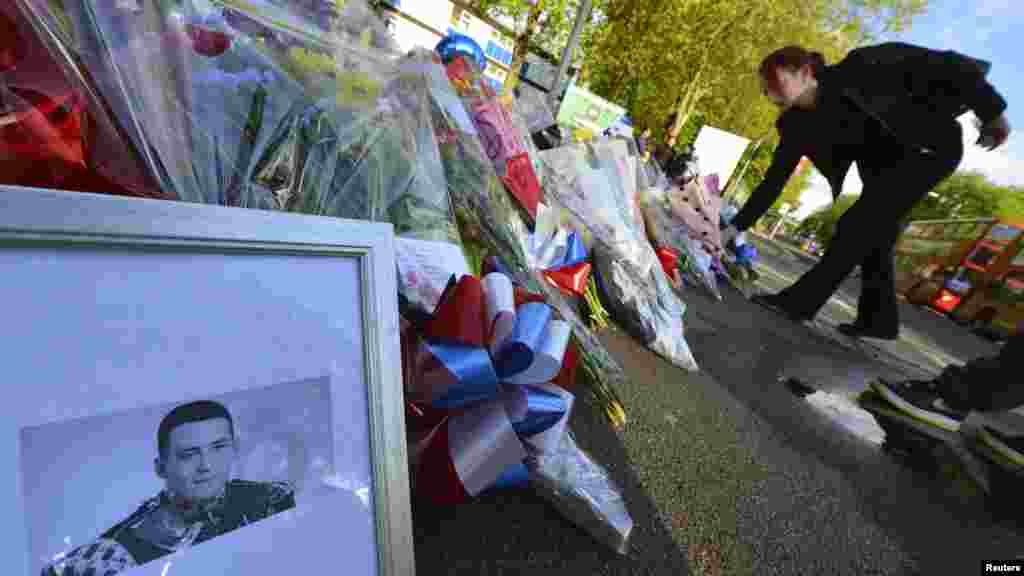 A picture of victim Drummer Lee Rigby, of the British Army is displayed with flowers near the scene of his killing in Woolwich, southeast London May 23, 2013.