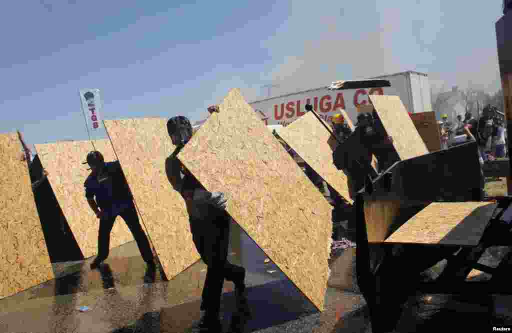 Protesters take cover as riot police use water cannons and tear gas to disperse them in Silivri,Turkey.