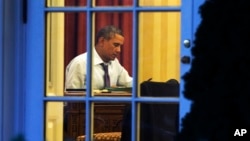 El presidente Barack Obama fotografiado desde la Rosaleda de la Casa Blanca, preparando su discurso de esta noche.