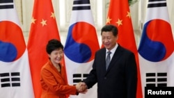 Presiden China Xi Jinping (kanan) berjabat tangan dengan Presiden Korea Selatan dalam pertemuan APEC di Beijing (10/11).