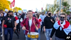 A protester beats a drum during a Belarusian opposition supporters' rally protesting the official presidential election results in Minsk, Belarus, Sunday, Sept. 20, 2020.
