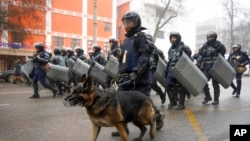 Polisi anti huru hara berjalan untuk memblokir demonstran yang berkumpul selama protes di Almaty, Kazakhstan, 5 Januari 2022. (Foto: AP)