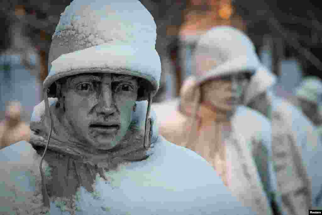 A light dusting of snow from an overnight storm covers the statues at the Korean War Memorial in Washington, D.C. early Friday morning. After a storm blew through the region overnight, roads were being cleared and many schools systems were closed. 