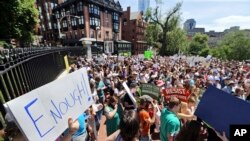 People rally outside the Statehouse, in Boston, June 20, 2018, to protest how immigrants are being treated both on the border with Mexico and in Massachusetts.