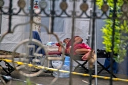 Seorang pasien berbaring di ranjang dalam tenda darurat yang didirikan untuk menampung lonjakan pasien terinfeksi COVID-19, di Rumah Sakit Umum Dr. Sardjito Yogyakarta, Rabu, 7 Juli 2021. (AP)