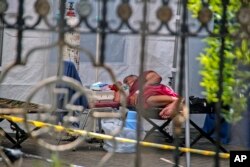 Seorang pasien terbaring di dalam tenda darurat yang didirikan untuk menampung lonjakan kasus infeksi COVID-19, di Rumah Sakit Umum Dr. Sardjito Yogyakarta, Rabu, 7 Juli 2021. (Foto: AP)