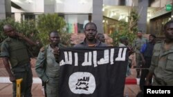 Funcionarios de seguridad de Mali muestran una bandera yijadista que dicen pertenece a los atacantes del hotel Radisson en Bamako. Nov. 20 2015. REUTERS/Joe Penney.