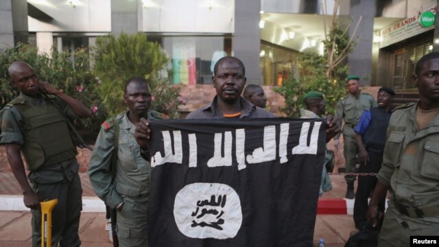 Funcionarios de seguridad de Mali muestran una bandera yijadista que dicen pertenece a los atacantes del hotel Radisson en Bamako. Nov. 20 2015. REUTERS/Joe Penney.