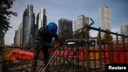 Workers prepares an iron grid for welding at a construction site in the Central Business District, Beijing, China, October 27, 2020. 