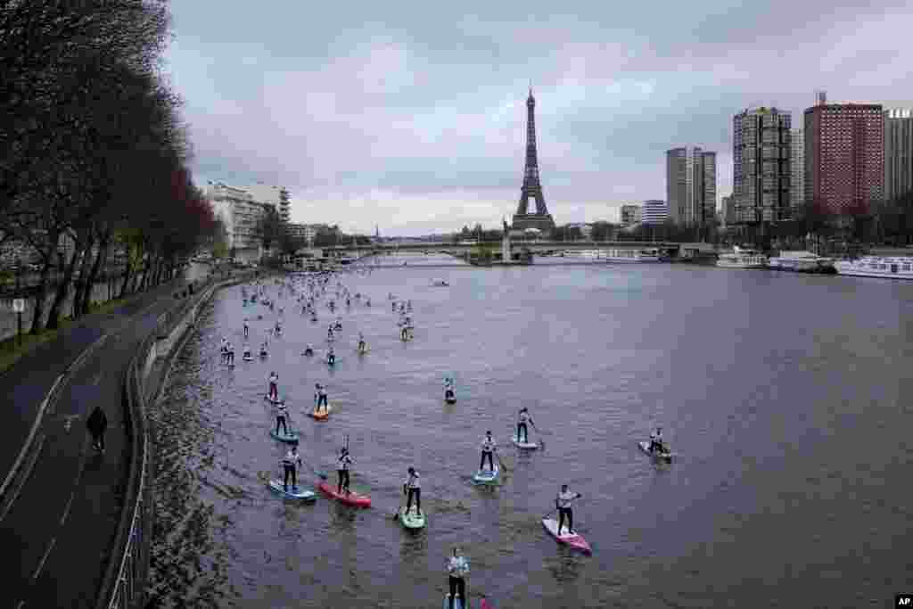 Competitors steer their stand up paddle boards during a race on the Seine river in Paris, France.