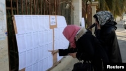 People look for their names at a polling station, Benghazi, Feb. 20, 2014.
