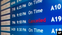 A departure board at the Philadelphia International Airport shows that US Airways Flight 796 to Tel Aviv has been canceled, July 22, 2014.
