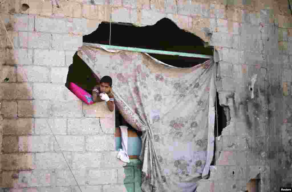 A boy looks out of his damaged house after a ceasefire was declared, in the east of Khan Younis in the southern Gaza Strip, Aug. 27, 2014.