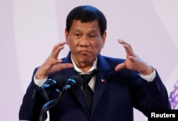 FILE - Philippines' President Rodrigo Duterte gestures during a news conference on the sidelines of the Association of South East Asian Nations summit in Pasay, metro Manila, Philippines, Nov. 14, 2017.