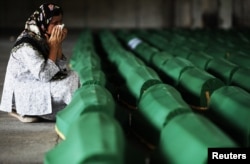 A Bosnian Muslim cries near the coffin of her relative, which was prepared for a mass burial at the Memorial Center in Potocari, near Srebrenica, July 10, 2012.