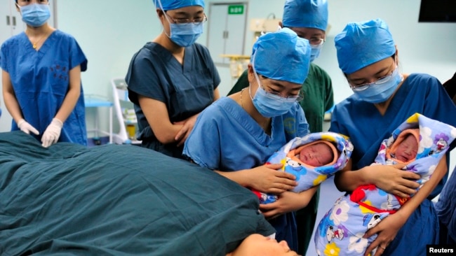 中国陕西西安一家医院的护士把两个双胞胎新生儿展示给他们的妈妈。（资料照片）